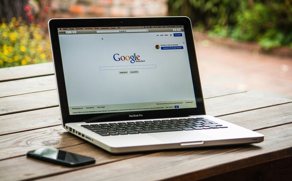 Laptop open to a search engine page outdoors.