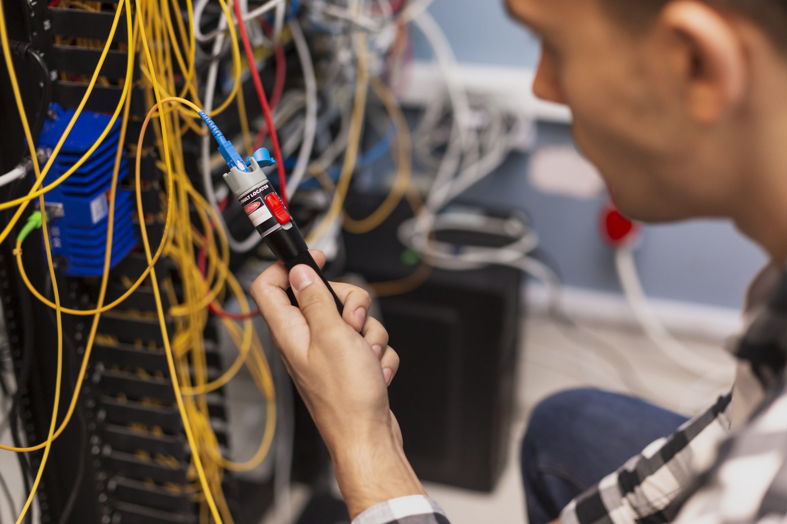 Technician testing fiber optic cable with visual fault locator